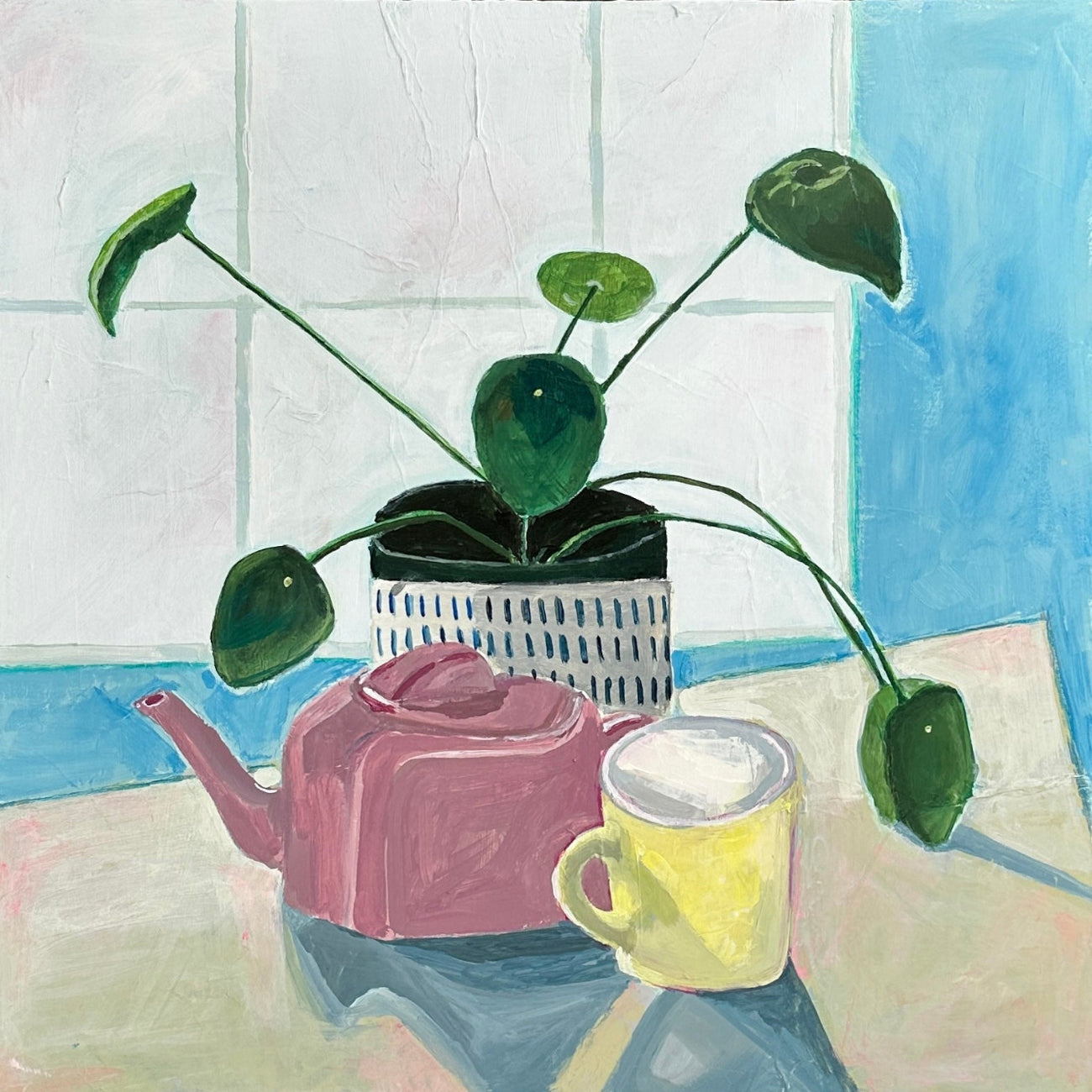 still life of a money plant, pink teapot, and yellow mug on a table in front of a window.