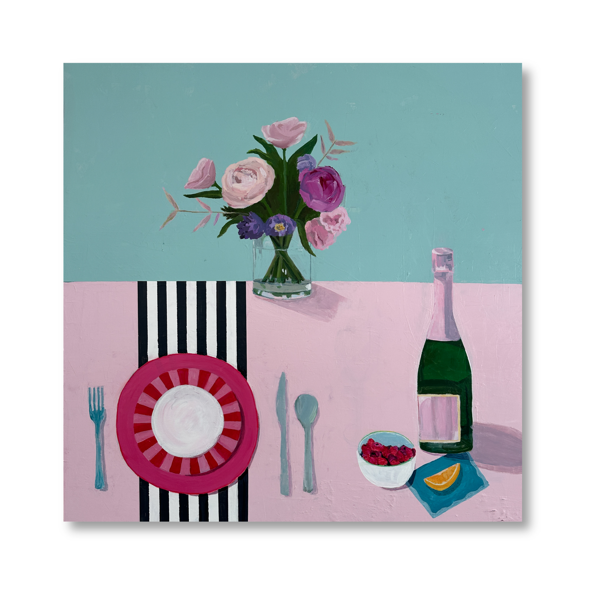 A pastel tabletop setting with a pink striped plate, utensils, a bottle of champagne, a bowl of raspberries, and a bouquet of flowers in a clear vase.